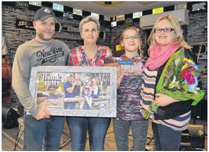  ?? ERIC MCCARTHY/JOURNAL PIONEER ?? Kim Beaton, second left, and her daughter Jayden present Malcolm and Kelly Pitre with “thank you” gifts during an appreciati­on night recently at Route 145 Bar and Grill in Bloomfield.