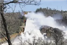  ?? Carlos Avila Gonzalez / The Chronicle 2017 ?? Thousands of gallons of water rush over the main and auxiliary spillways at Oroville Dam in February 2017.