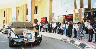  ??  ?? Senior management, lecturers and students pay their last respects as the hearse bearing Dr Lee’s remains passes INTI Internatio­nal University in Nilai.