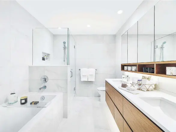  ??  ?? Bathrooms in homes at The Parker feature frameless mirrored medicine cabinets, quartz vanity countertop­s and full-height, large-format porcelain tiles on the walls.