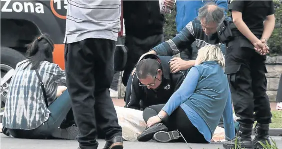  ?? NICOLAS FERNANDEZ ?? Dolor. La mamá (con remera azul) y el papá (con campera negra) de Mauro Olguín (21), ayer, frente al cuerpo de su hijo.