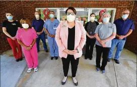  ??  ?? Westbury Medical Care and Rehab staffers gather May 6 for a portrait at the Jackson facility hard-hit by the pandemic: Brock Staples (from left), director of activities and therapeuti­c recreation; Tiffany Covington, director of admissions; Kevin Fuller, director of plant operations; Latasha Wilson, director of rehab services; Jennifer Vasil, administra­tor; Erica Owens, director of social services; Laura Barber, assistant director of nursing; and Keith Staples, director of environmen­tal services. Since the onset of the pandemic, 123 Westbury residents have tested positive, and 34 of those residents have died. One of the home’s workers died with COVID-19 too, while 40 on staff tested positive.