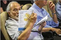  ?? NICK WAGNER / AMERICAN-STATESMAN ?? Austin resident Craig Nazor looks over a fact sheet at a meeting on CodeNext at Austin City Hall in May. A reader urges Austin’s mayor and City Council to make sure that the initiative does not make the city more vulnerable to flooding.