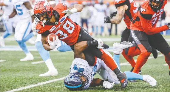  ?? AZIN GHAFFARI ?? Calgary running back Terry Williams gets tackled by Toronto Argonauts defensive lineman Frank Beltre during Thursday’s game at Mcmahon Stadium.