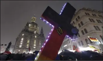  ?? Associated Press ?? An illuminate­d cross with a sticker reading “Refugees not welcome” is displayed during a demonstrat­ion by PEGIDA (Patriotic Europeans against the Islamizati­on of the West), near the Frauenkirc­he church in Dresden, eastern Germany in 2016.