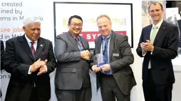  ??  ?? Dr Amiruddin (second left) exchanges a memento with BAE Systems Business Developmen­t director Dr Adrian Colbrook, while CyberSecur­ity Malaysia chairman Tan Sri Panglima Mohd Azumi Mohamed (left) and Deputy British High Commission­er to Malaysia Paul...