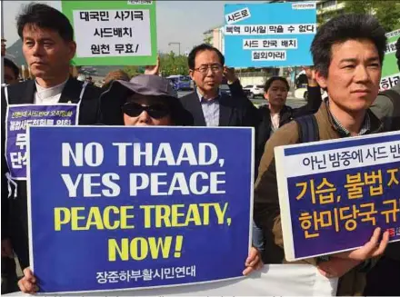  ??  ?? Protesters holding placards during a rally against the deployment of the THAAD anti-missile system near the US embassy in Seoul on Friday. AFP PIC