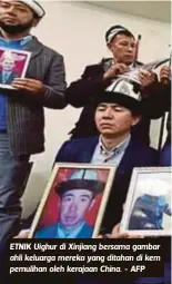  ??  ?? ETNIK Uighur di Xinjiang bersama gambar ahli keluarga mereka yang ditahan di kem pemulihan oleh kerajaan China. - AFP