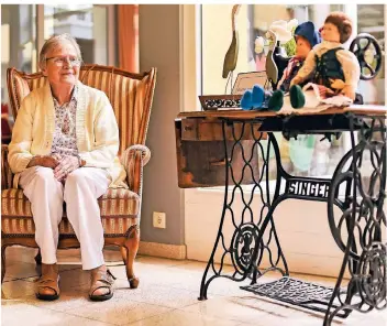 ?? FOTO: JANA BAUCH ?? Maria Iven sitzt im Foyer des Haus Tabita in Kleinenbro­ich und schaut ihre selbstgenä­hten Puppen an. Die Handarbeit hat Iven über ihr gesamtes Leben hinweg begleitet.