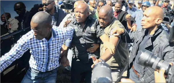  ?? PICTURE: PHILL MAGAKOE ?? Julius Malema is bundled into his car after being instructed by a senior police officer to leave Marikana, North-West Province, yesterday. The expelled ANCYL president had been on his way to address striking Lonmin mineworker­s at the local stadium.