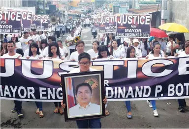  ??  ?? FAREWELL PROCESSION — Family members and supporters of slain Mayor Ferdinand Bote of Gen. Tinio, Nueva Ecija form a long funeral march with some of them bearing placards demanding justice for their beloved municipal official yesterday. (Ariel P. Avendaño