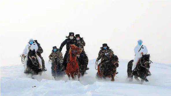  ??  ?? Border guards and medics ride in the snow during a patrol and visit to remote nomad families in Fuyun county, Altay, in northwest China’s Xinjiang Uygur Autonomous Region as part of the nation’s fight against Covid-19. GETTY IMAGES