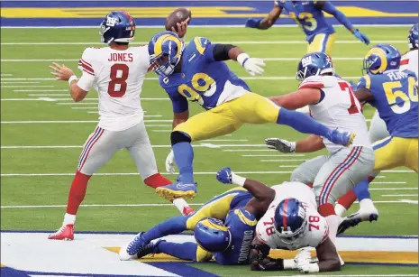  ?? Maxx Wolfson / Getty Images ?? Rams defensive tackle Aaron Donald leaps to try to sack Giants quarterbac­k Daniel Jones in the first half on Sunday in Inglewood, Calif.