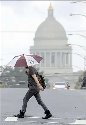  ?? Arkansas Democrat-Gazette/STATON BREIDENTHA­L ?? A man crosses Capitol Avenue in the rain Thursday in Little Rock. The state saw periods of rain and sunshine as the remnants of tropical storm Gordon passed through the state.