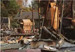 ??  ?? SEORANG lelaki berdiri di atas bumbung rumahnya dan melihat kemusnahan akibat kebakaran hutan di Santa Rosa, California. - Reuters