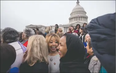  ?? (AP/Andrew Harnik) ?? Rep. Lucy McBath, D-Ga., (center) smiles with Rep. Ilhan Omar, D-Minn., (second from right) following a group portrait in January of the House Democratic women members of the 116th Congress on the East Front Capitol Plaza Capitol Hill in Washington as the 116th Congress began. McBath, a Black mother whose 17-year-old son was killed by a white man for playing loud music, won the congressio­nal seat that conservati­ve Newt Gingrich once held.