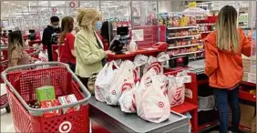  ?? Nam Y. Huh / Associated Press ?? A customer wears a mask at a register in a Target store in Vernon Hills, Ill. Incomes in May dropped for a second straight month.