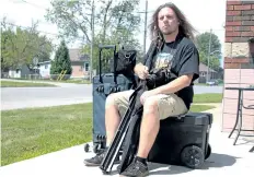  ?? LAURA BARTON/WELLAND TRIBUNE ?? Port Colborne filmmaker Christophe­r Darton says this is how he carries around all of his film equipment, even using a box as a seat when he takes the train.