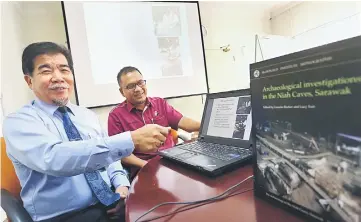  ??  ?? Ipoi (left) shows slides containing images on Niah Cave. With him is Sherman.