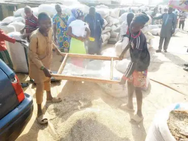  ?? ?? Some youths sieving sesame seed to remove sand from it at Sesame seed market in Kwali, FCT