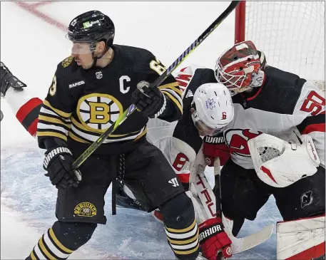  ?? MATT STONE — BOSTON HERALD ?? Brad Marchand #63 of the Boston Bruins looks back at the puck as John Marino #6 of the New Jersey Devils and Nico Daws #50 protect the net during the first period at the Garden.