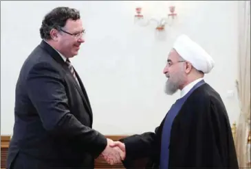  ?? IRANIAN PRESIDENCY/AFP ?? Iran’s President Hassan Rouhani (right) shakes hands with Patrick Pouyanné, chairman and CEO of French energy company Total, in Tehran on Monday.