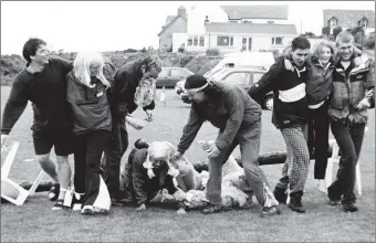  ?? 01_B28tweY03 ?? Competitor­s in the four-legged race get themselves in a tangle at an obstacle during the sports day.