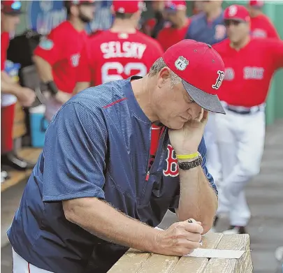  ?? STAFF FILE PHOTO BY MATT STONE ?? PLENTY OF OPTIONS: John Farrell goes over his notes during a recent workout in Fort Myers. The Red Sox manager believes plenty of relief pitchers will rotate through the roster during the 2017 season.