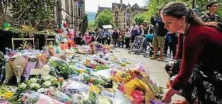  ?? Foto: Byrne ?? Stille Trauer: Menschen legen vor dem Rathaus am Albert Square Blumen für die Opfer ab.