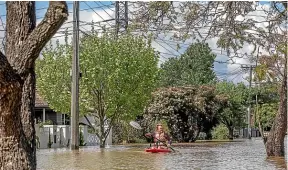  ?? GETTY IMAGES ?? A man canoes down a flooded street in the Melbourne suburb of Maribyrnon­g, whose residents are among the thousands of people evacuating their homes across Victoria.