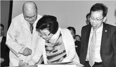  ??  ?? Datin Amar Kathryn Wee signs her pledge as a silent mentor witnessed by Dr Chin (left) and Dr Sim.