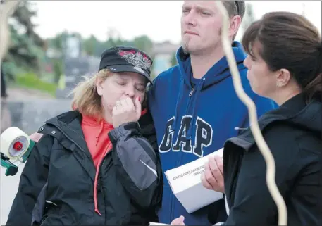  ?? Gavin Young, Calgary Herald ?? An emotional Angie Mosco gets a hug from family friend Ryan Jones on Saturday as she helps organize volunteers to head out and put up missing-person posters in an effort to find her father, Ralph Simington. The 67-year-old Simington was last seen in...