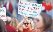  ?? DAVID ZALUBOWSKI/ASSOCIATED PRESS ?? An unidentifi­ed teacher holds up a placard during a Monday rally outside the state Capitol in Denver to demand better salaries.