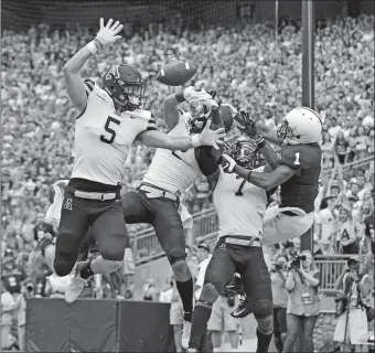  ?? CHRIS KNIGHT/AP PHOTO ?? Appalachia­n State defenders, from left, Thomas Hennigan, Corey Sutton and Josh Thomas break up a pass intended for Penn State’s KJ Hamler in the end zone during the first half Saturday in State College, Pa.