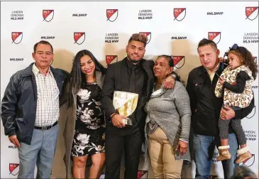  ?? JASON GETZ/SPECIAL TO THE AJC ?? Atlanta United’s Josef Martinez poses with family members after being awarded the Major League Soccer MVP award at the Arthur M. Blank Family Office on Wednesday in Atlanta.