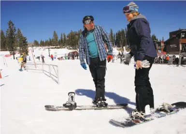  ?? Photos by Michael Macor / The Chronicle ?? Eric Whatley and Annie Tuft of Auburn get set to take off on their 50th day of snowboardi­ng this season at Northstar California Resort in Truckee. Tahoe-area businesses are seeing a rebound with the huge snowfall.