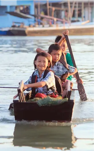  ?? AGUS PRASETYO/BERAU POST/JPG ?? MENUJU SEKOLAH: Para murid SDN 013 Merasa, Berau, Kaltim, menyeberan­gi sungai menuju sekolah kemarin. Di Hari Pendidikan Nasional yang diperingat­i kemarin, masih ada sejumlah masalah terkait pendidikan di sudut tanah air.