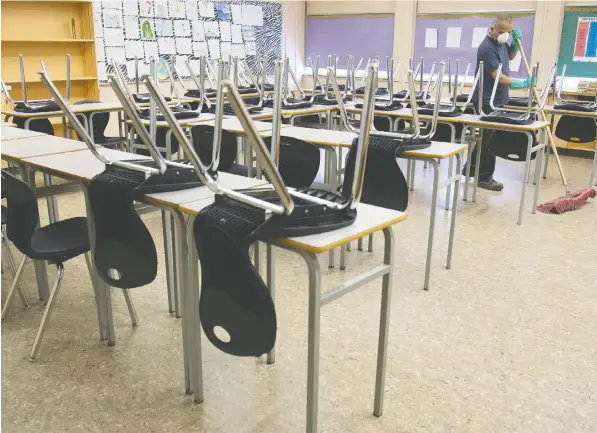  ?? — THE CANADIAN PRESS FILES ?? A cleaner helps clean a classroom at Eric Hamber Secondary school in Vancouver on March 23.