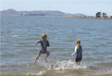  ?? Photo by Lee Suzuki / The Chronicle Sisters Stella ºleft» and Aleïa iGennaro of Walnut reek play at rown Memorial State Beach in Alameda. ??