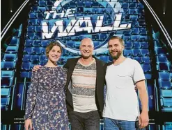  ??  ?? „The Wall“- Moderator Frank Buschmann mit den Gewinnern. Julia und Tobias Roloff hatten einen ganz besonderen Glücksbrin­ger dabei.