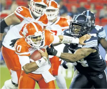  ?? VERONICA HENRI/POSTMEDIA NETWORK ?? B.C. Lions’ QB Jonathon Jennings is brought down by the Argos’ Victor Butler during CFL action in Toronto, on June 30.