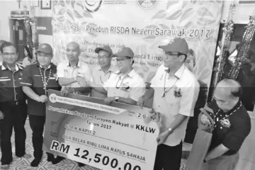  ??  ?? SMK Kapit 2 senior assistant Sidek Pawi (third left) accepts the mock cheque for RM12,500 from Nanta, witnessed by (from left) Edision, Kudi, Nyabong, Zulkefli and Tapah.