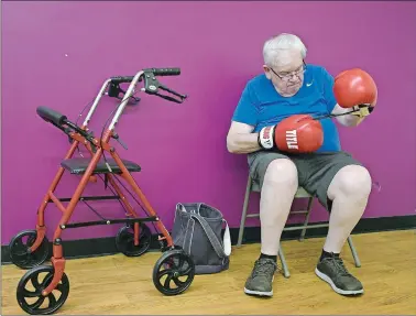  ?? RICK CINCLAIR/WORCESTER TELEGRAM & GAZETTE VIA AP ?? In a July 26 photo, Buzz Hamilton of Shrewsbury, Mass., trades his walker for boxing gloves during the DopaFit Parkinson’s Movement Center boxing class in West Boylston, Mass.