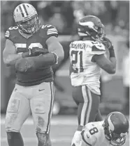  ?? MARK HOFFMAN / MILWAUKEE JOURNAL SENTINEL ?? Packers linebacker Nick Perry attends to his clubbed hand after sacking Vikings quarterbac­k Sam Bradford on Sunday.