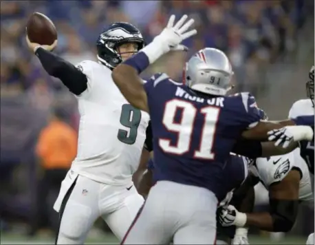  ?? CHARLES KRUPA — THE ASSOCIATED PRESS ?? Philadelph­ia Eagles quarterbac­k Nick Foles (9) passes under pressure from New England Patriots defensive end Deatrich Wise (91) during the first half of a preseason NFL football game, Thursday.