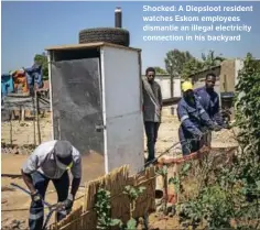  ?? Gallo Images/AFP/Michele Spata ?? Shocked: A Diepsloot resident watches Eskom employees dismantle an illegal electricit­y connection in his backyard