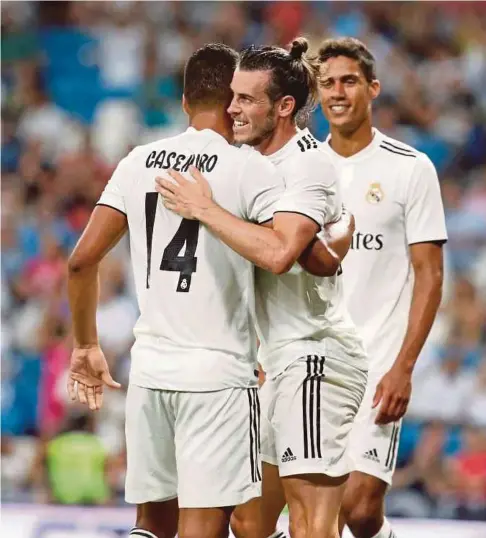  ??  ?? AKSI Bale (tengah) sejurus menjaringk­an gol ketika menentang AC MIlan.