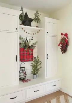  ??  ?? |ABOVE RIGHT| CUSTOM TOUCHES. The mudroom was another instance of Tracy customizin­g a space to fit her design goals. “There was a barn door that had been drawn in, so we had that changed so I could add the bench,” she says. The plaid bag was the inspiratio­n for her Christmas decor. “I used the deep red and olive green to find the same color ribbons and little trees on my dining table,” she says.
|BOTTOM| PLANTING DREAMS. Outside, Tracy chose to do the landscape design herself. “I had all the big trees put in so I could have a blank canvas to work with,” she says. Originally intended to house gardening supplies, this poolhouse, with a bathroom and kitchenett­e, is used for storage during the winter. Tracy and her husband are building a new greenhouse to create more space for her gardening.