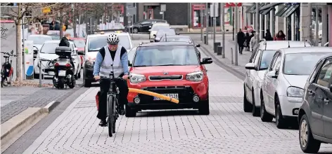  ??  ?? Frank Schopphoff testet auf der Telegrafen­straße mittels einer Pool-Nudel den Mindestabs­tand. An der Haltestell­e Rathaus kommt niemand an ihm vorbei.