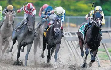  ?? Matt Hazlett Getty Images ?? CLASSIC EMPIRE, right, leads into the homestretc­h, but Cloud Computing, left, will chase him down.